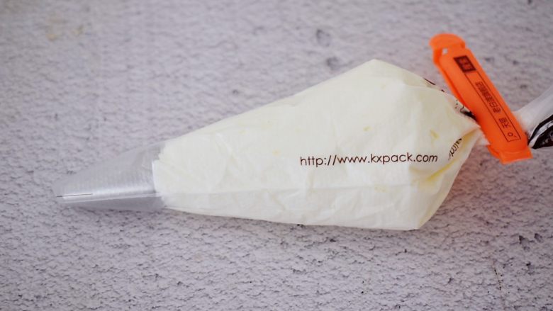 黑芝麻慕斯蛋糕,裱花袋加入中号圆形裱花嘴,再把淡奶油装入