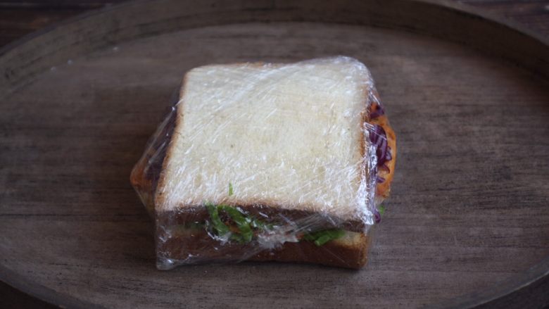蒸烤鸡胸时蔬三明治(便携美食),用塑料薄膜裹紧。