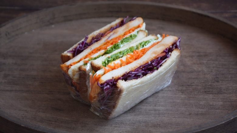 蒸烤鸡胸时蔬三明治(便携美食),再用刀将做好的三明治切开。