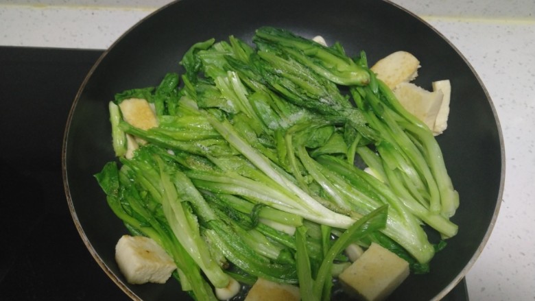 冻豆腐炒油麦菜,炒至断生，加入盐。