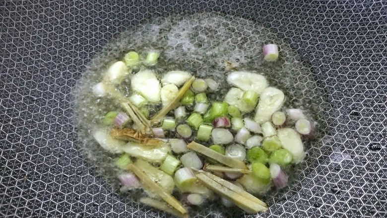 家常焖鱼,另起油锅,大火,把姜葱蒜倒入炒香。