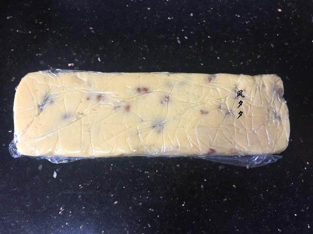 核桃饼干,在饼干盒模具内铺上保鲜膜,把面团整理平整,如果没有保鲜盒你可以借助保鲜膜的盒子,或者用刮板整理成大约成宽约6cm,高约4cm的长方体,放入冰箱冷冻一个小时。