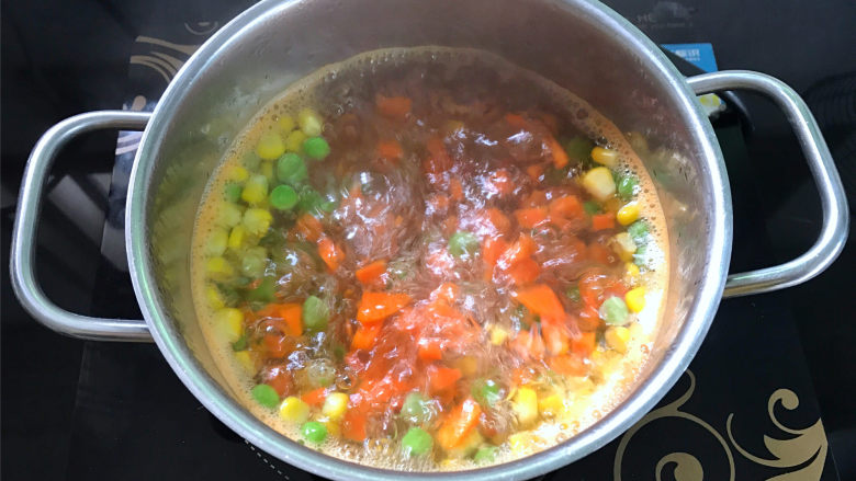 鲜虾小披萨,1小段胡萝卜去皮后切成小粒,和玉米粒和豌豆加少许盐一起焯熟。