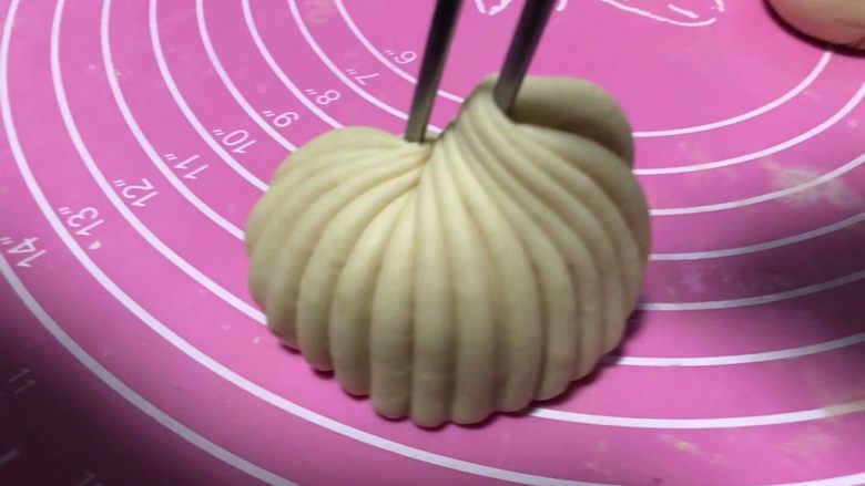贝壳馒头,筷子合拢后,提起筷子,贝壳的形状就出来了。