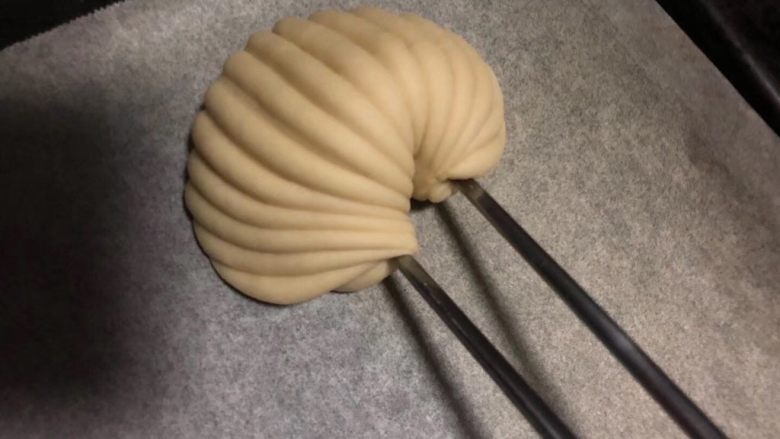 贝壳馒头,稍微整理一下形状,轻轻安放在蒸架上。
