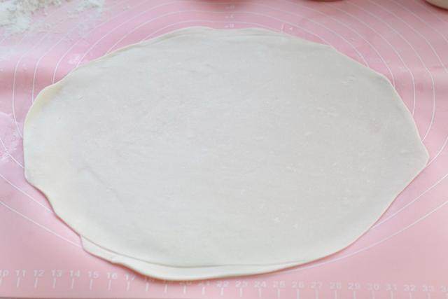 蒸春饼,再用擀面杖擀成薄薄的大圆片,不用刻意追求对称,尽量擀圆、擀薄即可;