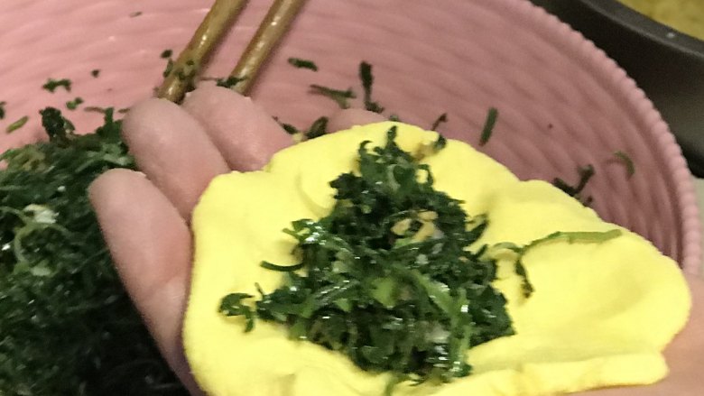 野菜团子,取一份玉米面团用手按扁，加入适量馅料。