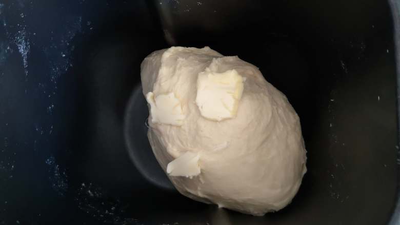 葡萄干小面包,当面团能拉出较粗的薄膜时,加入黄油,继续揉面。