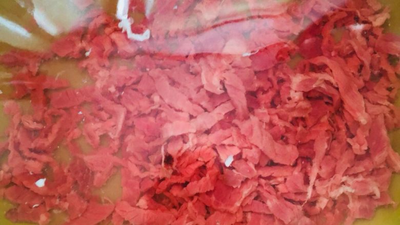 洋葱青椒炒牛肉,切好的牛肉丝放在清水里浸泡一会儿,泡去血水后再洗净捞出