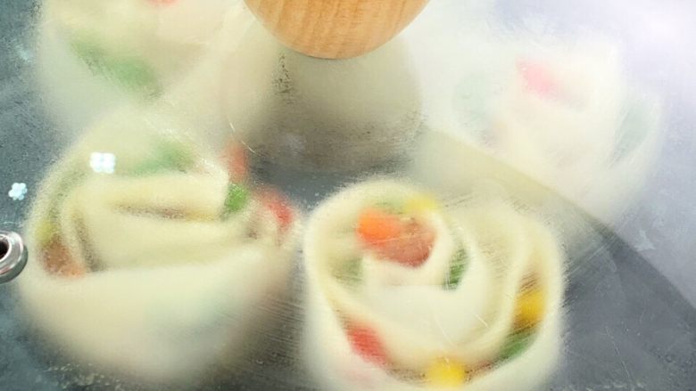玫瑰蛋包饺,平底锅加入淋入热炒油将饺子煎至底部金黄;加入清水盖好锅盖焖熟。