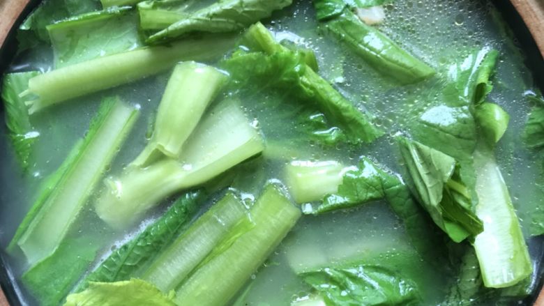 芥菜沙白汤,把芥菜放入锅里煮着沸腾。