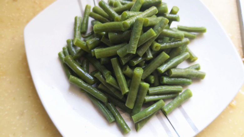 凉拌豆角,豆角放到盘子里,