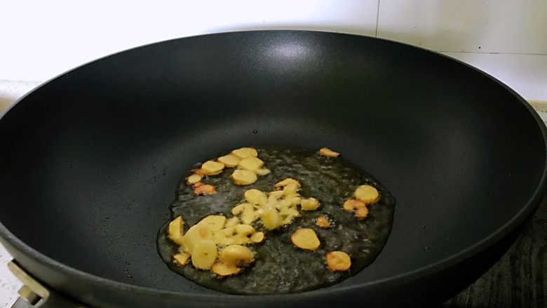 油菜香菇,热锅中加入油,放入蒜炒出香味。