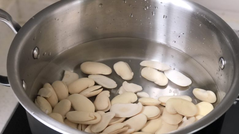 白豆沙,白芸豆放入锅中,倒入适量清水中火煮,水沸以后继续加热5分钟左右关火,将豆子倒入沥水篮中冲洗表面浮沫,再倒回锅中重新加水到没过豆子煮第二次,重复三次。
