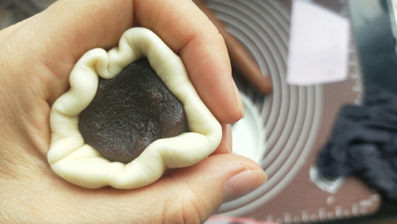 苹果豆沙包,把豆沙馅包进去,然后用虎口这里慢慢往小收拢。