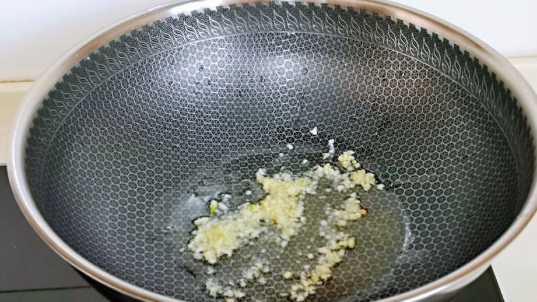 豌豆炒萝卜干,起油锅,加入蒜末炒出香味。