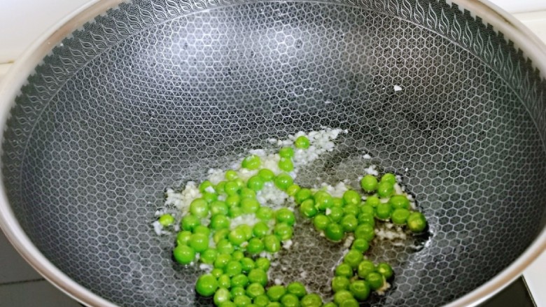 豌豆炒萝卜干,加入豌豆粒煸炒2分钟。