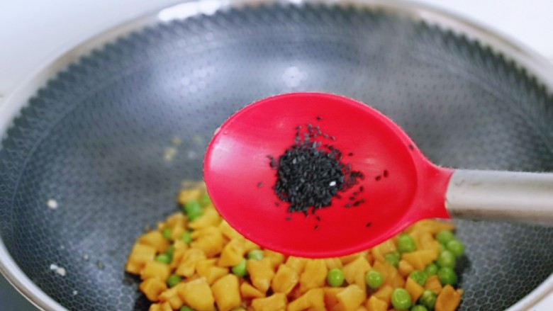 豌豆炒萝卜干,再加入<a style='color:red;display:inline-block;' href='/shicai/ 141774'>熟黑芝麻</a>翻炒均匀,关火出锅。