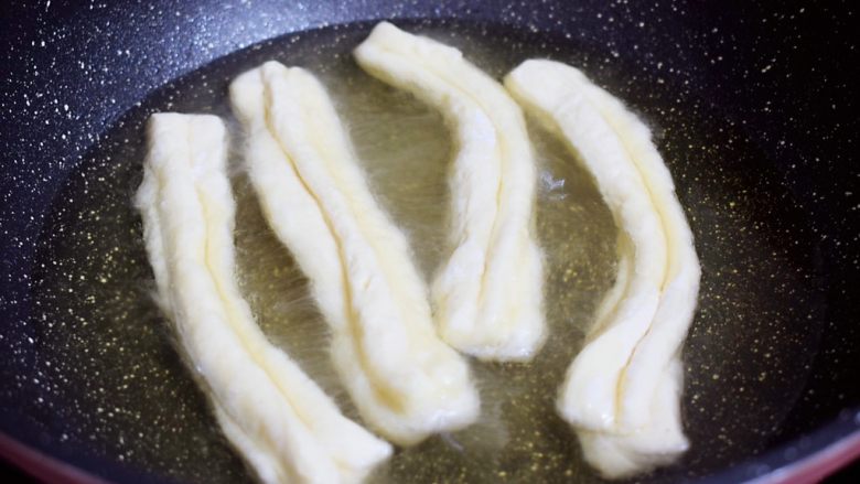 自制健康油条,锅中倒入适量的食用油,待油温7-8成热时,放入油条生胚