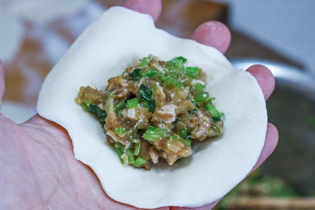 猪肉馅饼,面团醒好之后,我在面板上撒一点干面粉,将面团揉几下,分成小份;取一个面团,搓圆,压扁,用擀面杖擀开,包入馅料。像包包子一样捏紧;