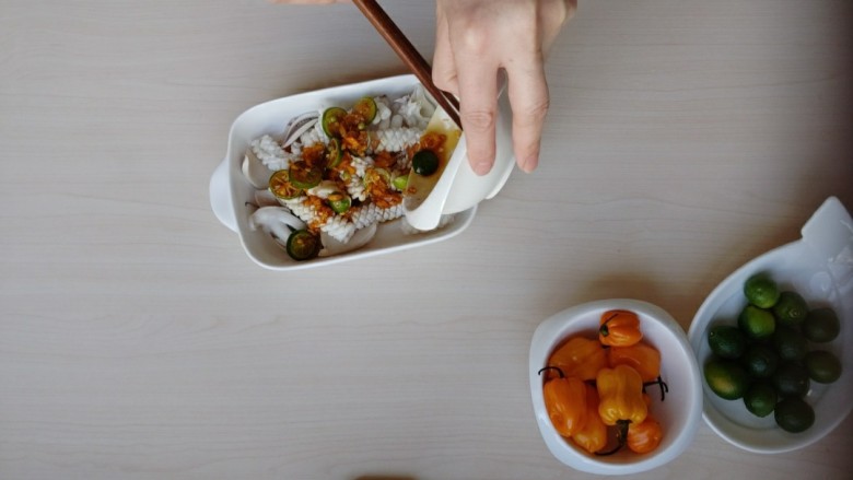 鲜辣酸柑鱿鱼,鱿鱼捞出控水放入盘中,将调好的料汁倒入鱿鱼中。