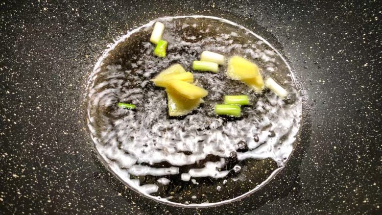 酸菜土豆烧春笋,热锅放入适量油,放入葱白和姜片炒出香味。