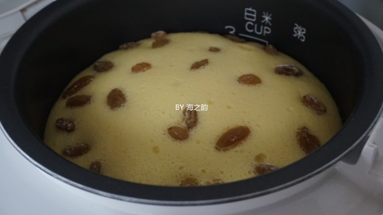 电饭锅戚风蛋糕,时间到,继续焖5分钟,再开盖,可以明显看到,做好的蛋糕比刚才倒入的蛋糕糊足足高了3CM,把内胆取出倒扣在晾架上。