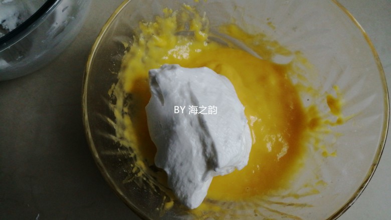 电饭锅戚风蛋糕,用刮刀把1/3打发好的蛋白霜到蛋黄糊里,从底部向上翻拌并切拌均匀,不要划圈翻拌