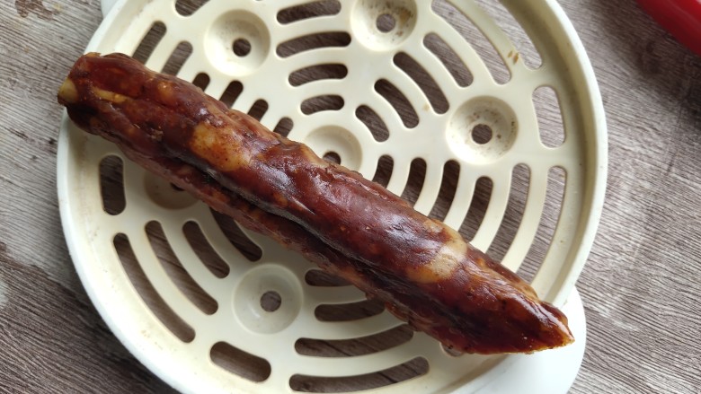 西葫芦炒腊肠,取一根腊肠,大约100克左右,洗干净之后要上锅蒸熟。
