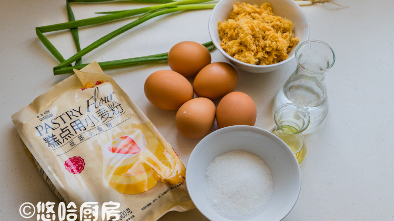 葱香肉松蛋糕,先备齐材料,温开水是70度左右的水。小葱洗净切碎(葱白不用,光用葱叶)放烤盘里,放烤箱中层150度烤15~20分钟,目的是去掉小葱中的部分水分。