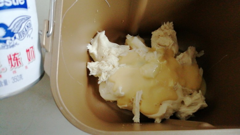 炼乳花环面包,将中种面团撕成小块放入面包桶,倒入炼奶、蛋液、26克水和盐