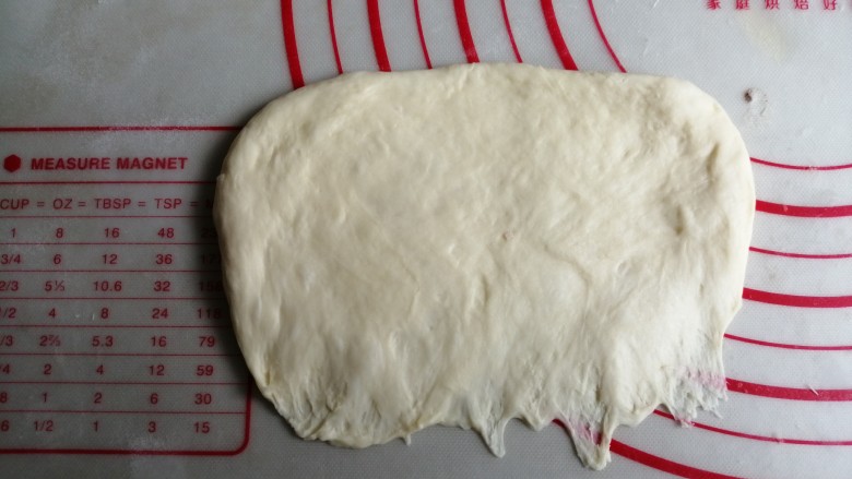 炼乳花环面包,擀成椭圆形,将光滑面朝下,压薄底边
