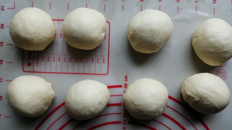 炼乳花环面包,将面团取出,轻压排气,分成8份,滚圆后盖上保鲜膜,松驰20分钟