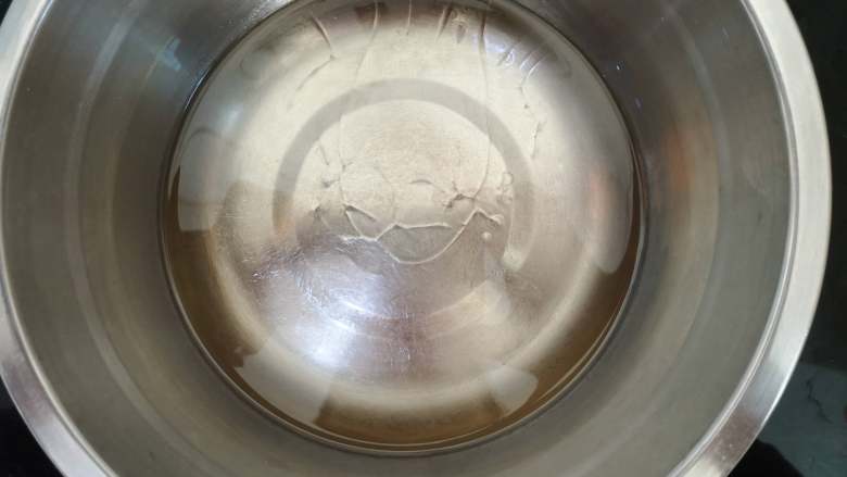 古早蛋糕,将装有食用油的不锈钢盆用电磁炉小火加热,当油面出现纹路时,将低筋面粉全部倒入食用油中。