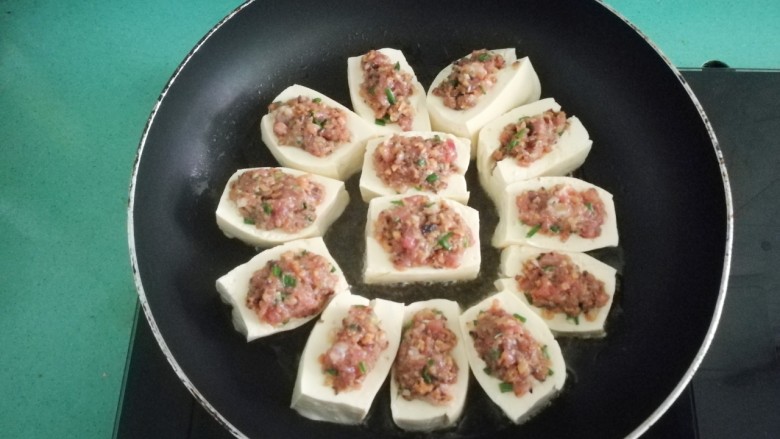 客家美食《砂锅煲咸菜酿豆腐》,将酿好的豆腐放入锅中,摆放整齐,盖上盖子中小火慢慢煎,本来我打算直接煎好加入适量酱油,勾点芡汁撒点胡椒粉,也是好美味的。可是我突然又很想念老家的<a style='color:red;display:inline-block;' href='/shicai/ 4207'>咸菜</a>酿豆腐煲,谁让我们的酿豆腐怎么做都好吃呢😜