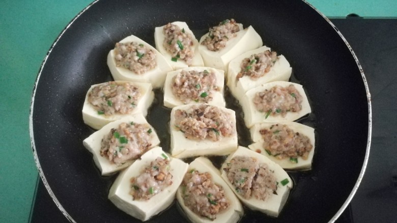 客家美食《砂锅煲咸菜酿豆腐》,煎到肉馅定型不散即可,过年时酿的多了,就全部蒸熟,然后放冰箱冷藏,想吃几个煎几个吃