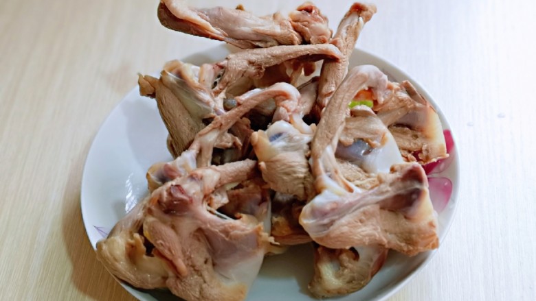 香烤鸭锁骨,捞出用温水反复冲洗,将鸭锁骨上的杂质冲洗干净。