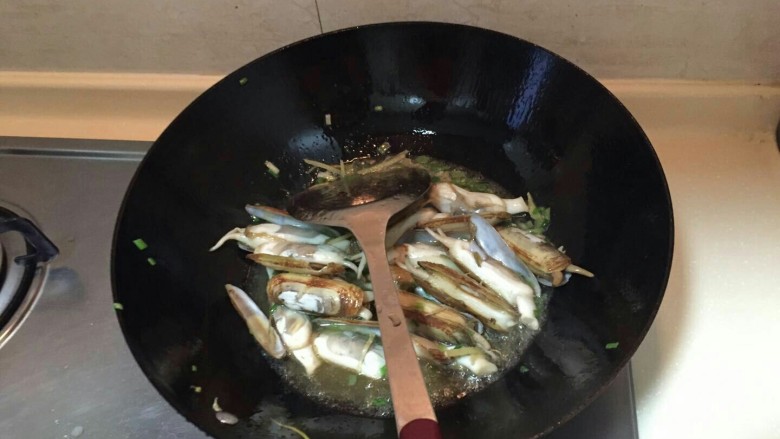 海鲜蛏子面,倒油,中火。放入小葱,再倒入蛏子翻炒2分钟