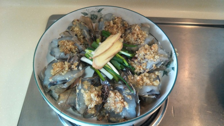 黄油蒜蓉蒸大虾,加入葱段姜片,表面可以撒一点<a style='color:red;display:inline-block;' href='/shicai/ 134333'>黑胡椒</a>。