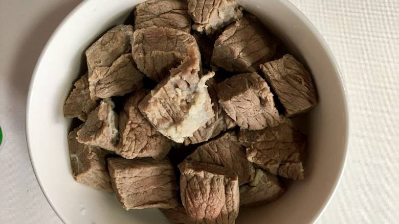 麻辣牛肉干丝,牛肉切成小块,放入冷水中浸泡1小时左右,浸出肌肉中的血水,洗干净沸水去腥捞出沥干备用。你可以切成长块状,做出来的丝会比较的漂亮,我少说一句话,老公就切成这样啦,呜呜