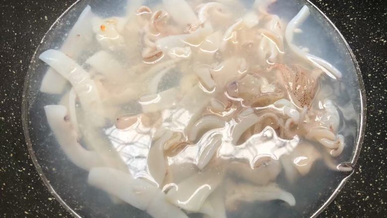 芦笋炒鱿鱼,锅里放入一大碗水烧开,把鱿鱼放入焯烫1分钟,焯好捞起来用冷水冲洗干净待用。