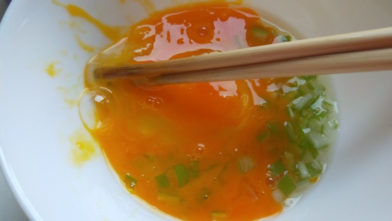 早餐鸡蛋灌饼,碗中打入一个鸡蛋,加入葱花,盐,搅拌均匀。