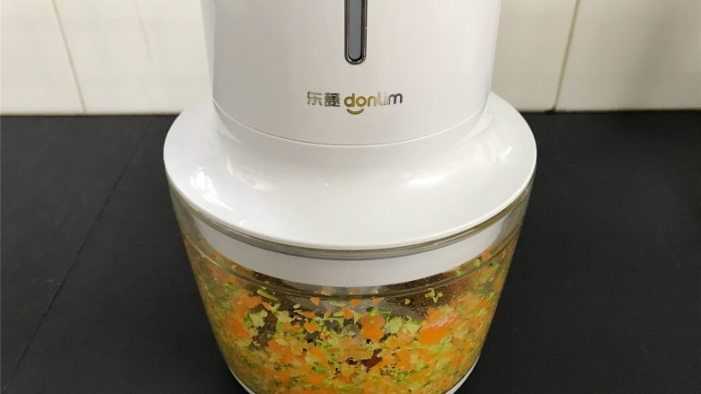 西兰花肉松饭团,焯过水的西兰花和胡萝卜捞出后沥干水分,放入料理机中,打成蔬菜末。