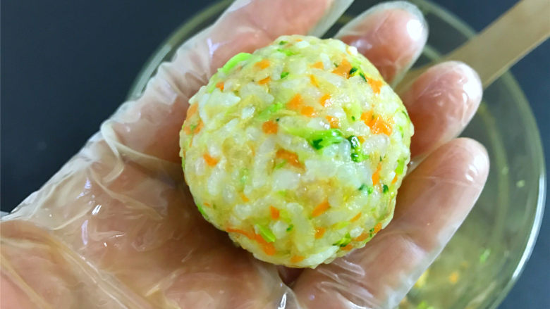 西兰花肉松饭团,戴上一次性手套,取适量米饭,搓捏成饭团就可以了。