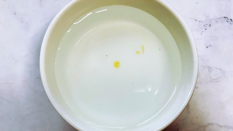 自制黑芝麻丸,准备一碗凉水,用筷子醮一点蜂蜜滴到水里,呈凝固的状态,不会马上散开就可以了。