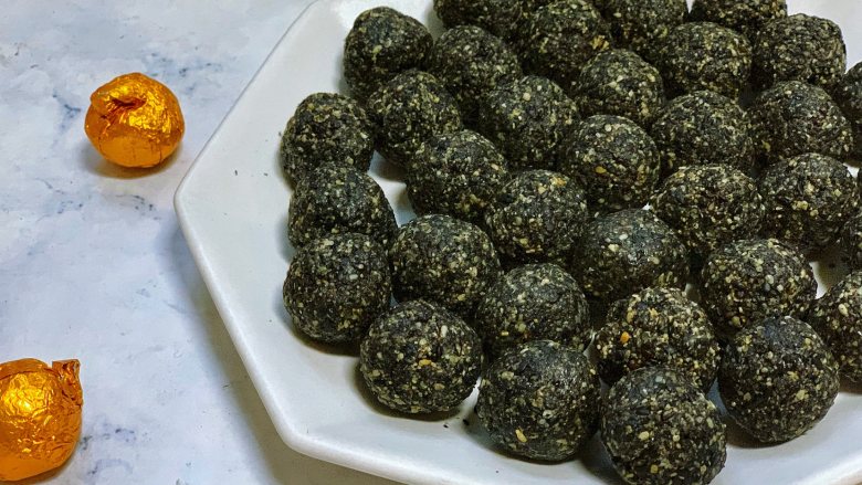 自制黑芝麻丸,用手搓成10克1个的小芝麻丸,多揉几下,芝麻丸就会出油,黑亮亮的,光泽特别诱人,切记一定要趁热揉哦,捏紧实一些,否则冷了就会变硬,不好揉搓了。