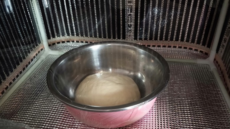 火腿香葱小面包,盖保鲜膜进行第一次发酵。我用发酵箱,30度,发酵一个小时