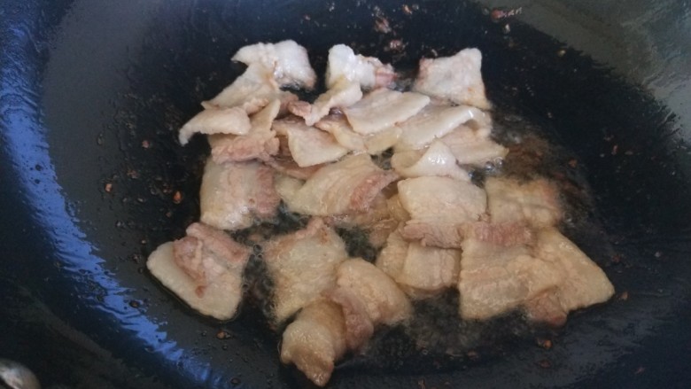 五花肉炒蒜苔,锅中倒入油,倒入五花肉片炒出油。