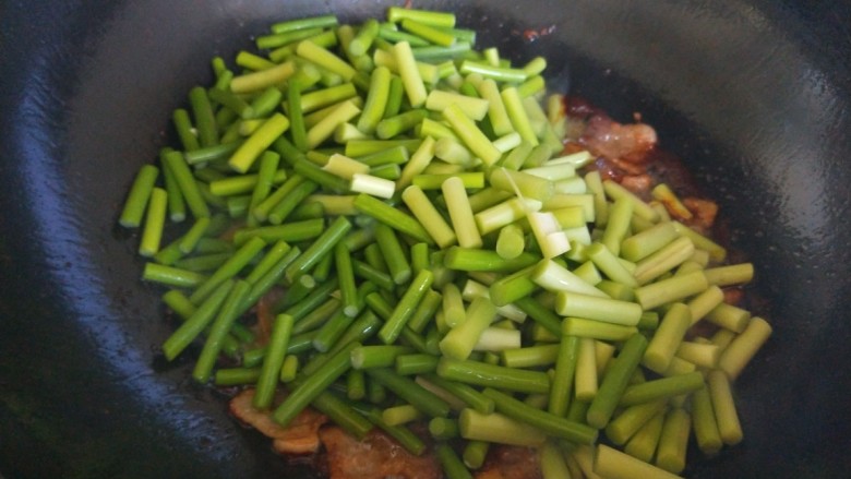 五花肉炒蒜苔,倒入蒜苔。