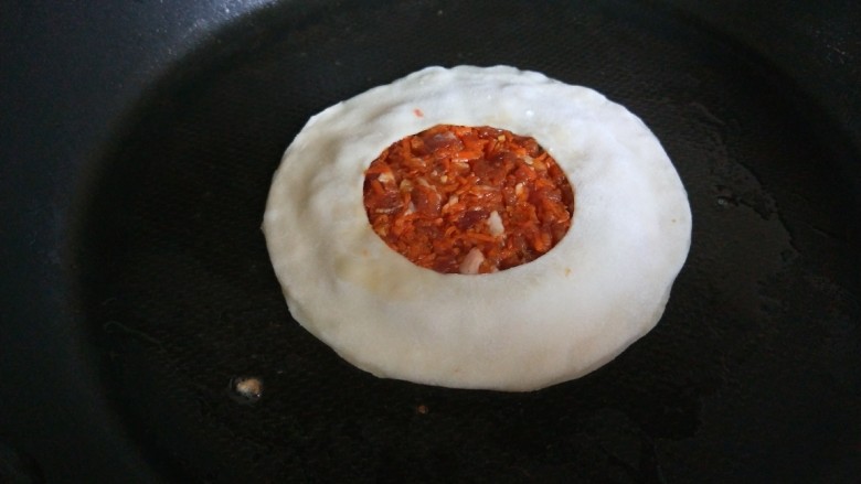 猪肉胡萝卜馅灌鸡蛋饼,平底锅烧热倒入适量油,放入锅中煎制。